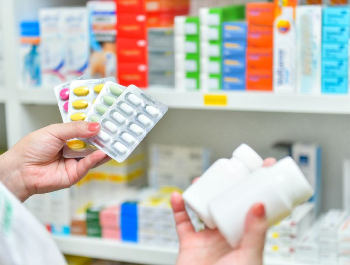 Hands taking tablets out of a medicine cabinet