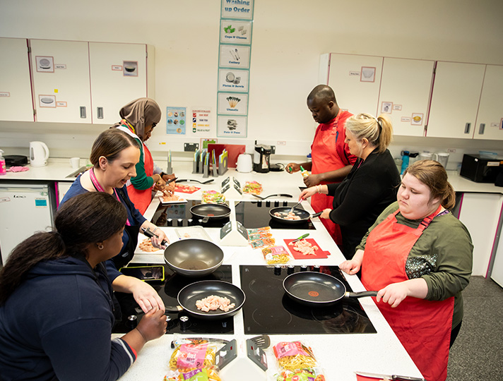 Students  cooking in the independent living kitchen