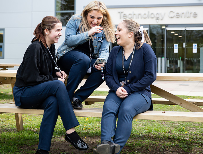 students outside sitting on a bench